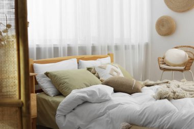 Yumuşak yastıkları ve odada yorganı olan büyük, rahat bir yatak. Ev tekstili