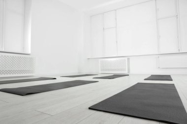 Egzersiz paspasları, büyük pencereleri ve düşük açılı manzaralı geniş yoga stüdyosu.