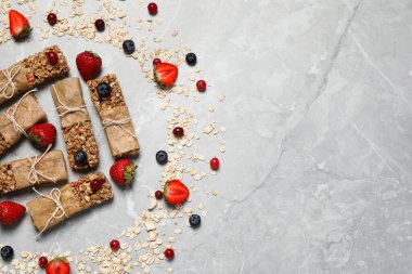 Lezzetli granola barlar ve açık gri mermer masa üzerindeki malzemeler düz. Metin için boşluk