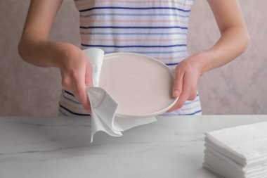 Beyaz mermer masada kağıt mendille silen kadın, yakın plan.