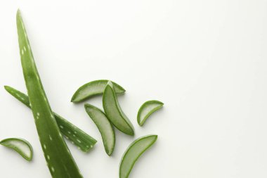 Beyaz arka planda taze aloe vera parçaları, düz. Metin için boşluk
