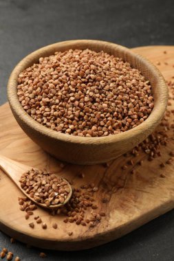 Siyah masadaki kuru karabuğdaylı kase ve kaşık, yakın plan.