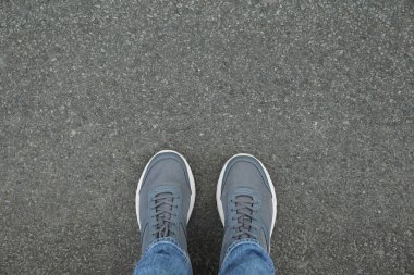Spor ayakkabılı bir adam asfaltta duruyor. Metin için boşluk