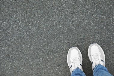 Spor ayakkabılı bir adam asfaltta duruyor. Metin için boşluk