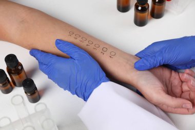 Doktor ışık masasında cilt alerjisi testi yapıyor, yakın plan.