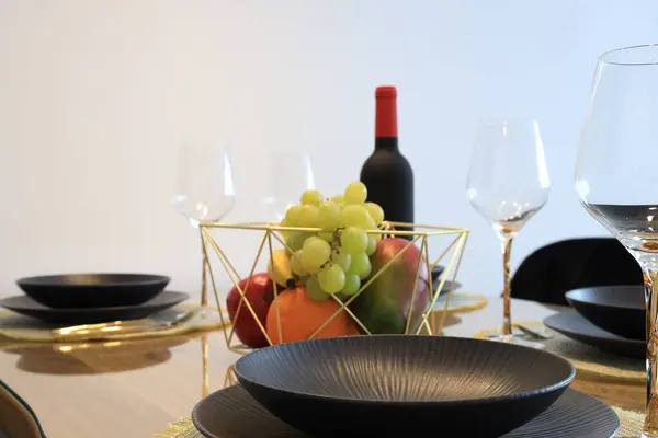 Bottle of wine and fruits on table served for dinner indoors