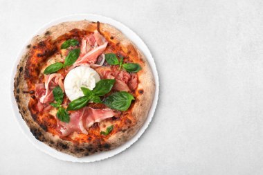 Burrata peynirli lezzetli pizza, fesleğen ve jambon açık gri masada, üst manzara. Metin için boşluk