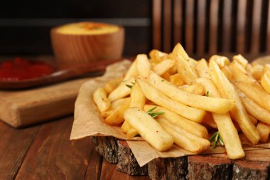 Ahşap masada biberiyeli patates kızartması, yakın plan. Metin için boşluk