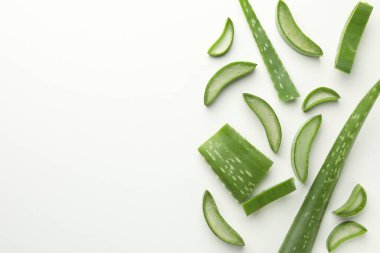 Beyaz arka planda taze aloe vera parçaları, düz. Metin için boşluk