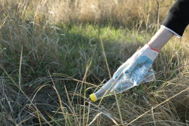 Dışarıdan plastik şişe alan bir kadın, yakın plan. Metin için boşluk