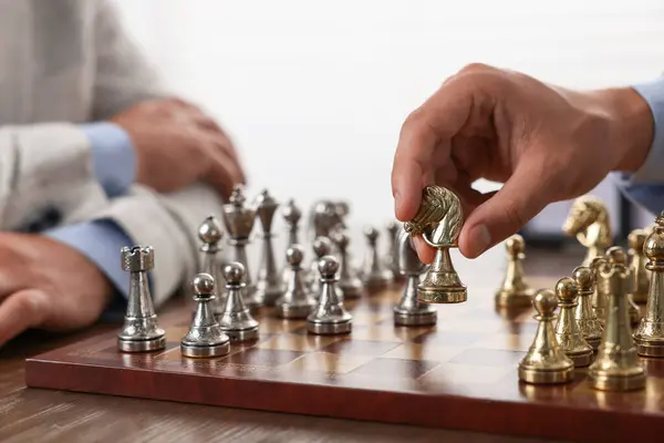 Men playing chess during tournament at table, closeup