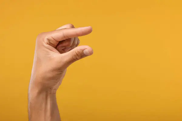 Man Håller Något Handen Orange Bakgrund Närbild Plats För Text — Stockfoto