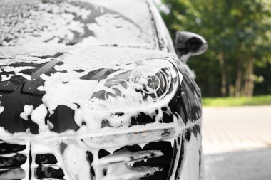 Oto temizleme köpüğüyle kaplanmış. Açık oto yıkama, yakın çekim.