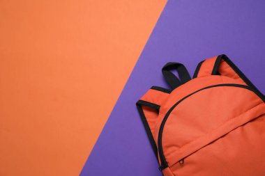 Renkli arka planda turuncu sırt çantası, üst manzara. Metin için boşluk