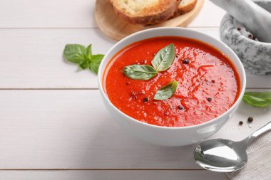 Lezzetli domates kremalı çorba beyaz ahşap masa üzerinde, metin için yer