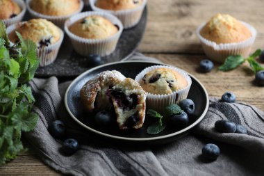 Yaban mersinli lezzetli çörekler ve ahşap masada nane şekeri.