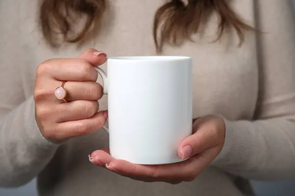 Woman holding white mug, closeup. Mockup for design
