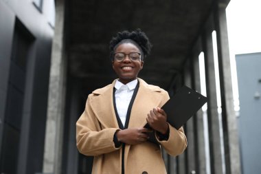 Dışarıda panosu olan mutlu bir kadın. Avukat, iş kadını, muhasebeci ya da müdür.