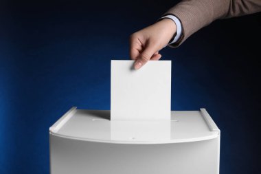 Woman putting her vote into ballot box on dark blue background, closeup clipart