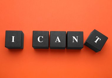 Motivasyon konsepti. I Can 'den I Can' e geçiş cümlesi turuncu arkaplandaki T harfli siyah tahta küpü kaldırarak yapılabilir.