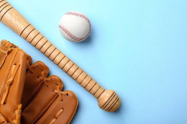 Beyzbol eldiveni, sopa ve top açık mavi arka planda, düz yerde. Metin için boşluk