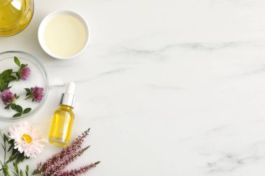 Beyaz mermer masa üzerinde kozmetik yağ şişesi ile düz kompozisyon, metin için boşluk