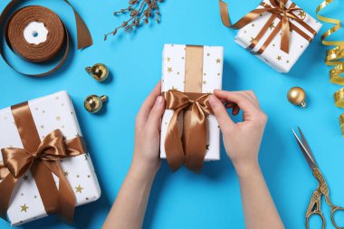 Açık mavi arka planda Noel hediyeli kadın, üst manzara