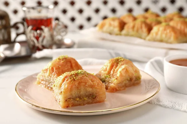 Delicious sweet baklava with pistachios on white table, closeup