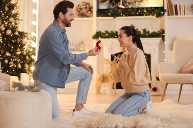 Nişan yüzüklü bir adam Noel 'de kız arkadaşına evlenme teklif ediyor.