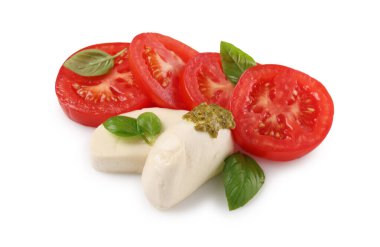 Domatesli lezzetli Caprese salatası, mozzarella peyniri, fesleğen yaprağı ve beyaz üzerine izole edilmiş pesto sosu.
