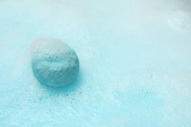 Açık mavi banyo bombası suda çözülüyor. Metin için boşluk