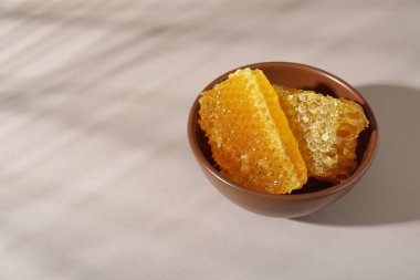 Beyaz masadaki kasede doğal bal petekleri, metin için boşluk