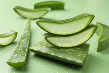 Yeşil arkaplanda taze aloe vera parçaları