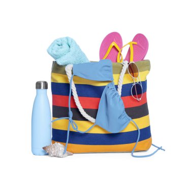 Şık çanta, deniz kabuğu ve beyaz üzerine izole edilmiş diğer plaj aksesuarları.