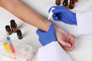 Doktor ışık masasında cilt alerjisi testi yapıyor, yakın plan.