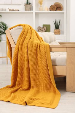 Oturma odasında turuncu battaniyeli rahat bir kanepe.