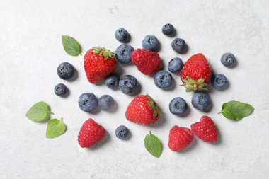 Beyaz desenli masa üzerinde bir sürü taze olgun böğürtlen yatıyordu.
