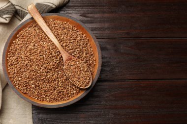 Tahta masadaki kuru karabuğdaylı kase ve kaşık, üst manzara. Metin için boşluk