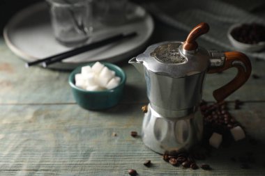 Moka demliği, kahve çekirdekleri ve şeker küpleri kırsal ahşap masa üzerinde, metin için yer