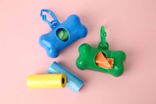 Мешки и диспенсеры для собак на розовом фоне, плоская укладка