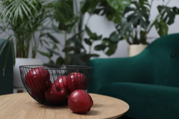 Red apples on side table in room, space for text
