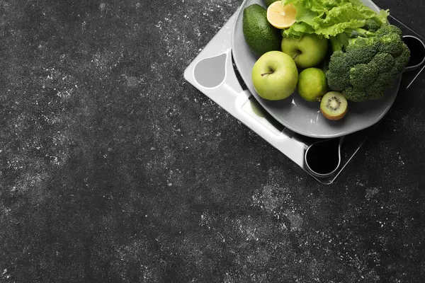 Healthy diet. Scale and fresh products on black textured table, top view with space for text