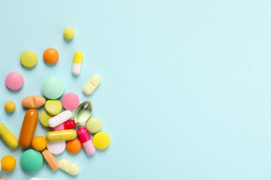 Açık mavi arka planda bir sürü farklı hap var. Metin için boşluk