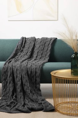 Rahat bir kanepe, battaniye ve oturma odasındaki yan masa.