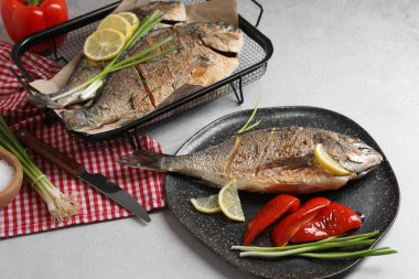 Yeşil soğan, dolmalık biber ve limonla servis edilen nefis pişmiş balık. Deniz ürünleri.