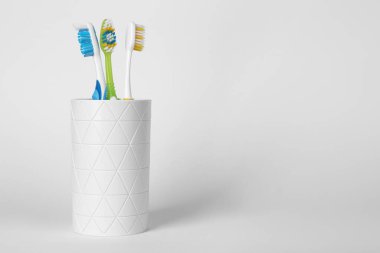 Açık gri arka planda farklı diş fırçaları var. Metin için boşluk