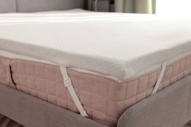 Gri yatakta beyaz köpüklü döşek.