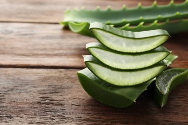 Taze aloe vera dilimleri ahşap masada, yakın plan. Metin için boşluk