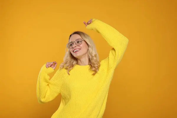 Vrolijke Vrouw Stijlvolle Warme Trui Bril Oranje Achtergrond — Stockfoto