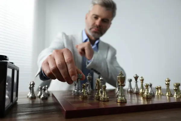 Man playing chess during tournament at table, selective focus